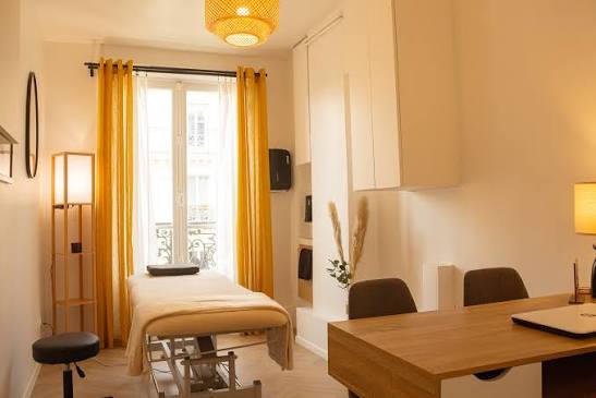 Cabinet d'ostéopathie parisien : table de soin, bureau et lumière naturelle